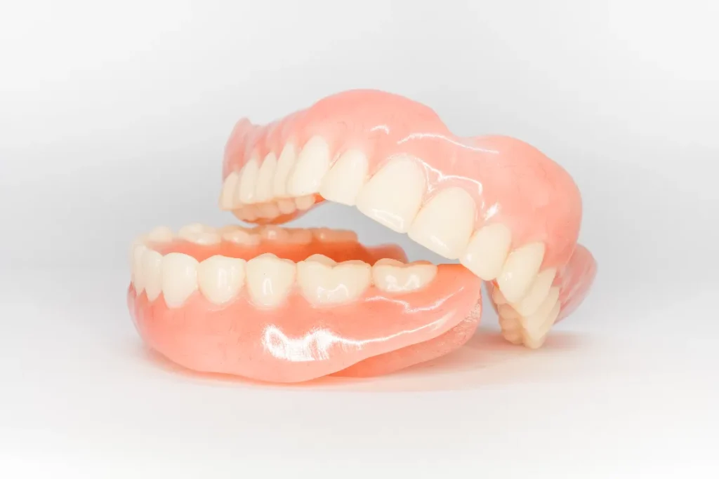 Close-up of full upper and lower dentures used to restore missing teeth and improve chewing and speech at Pearl Dental.